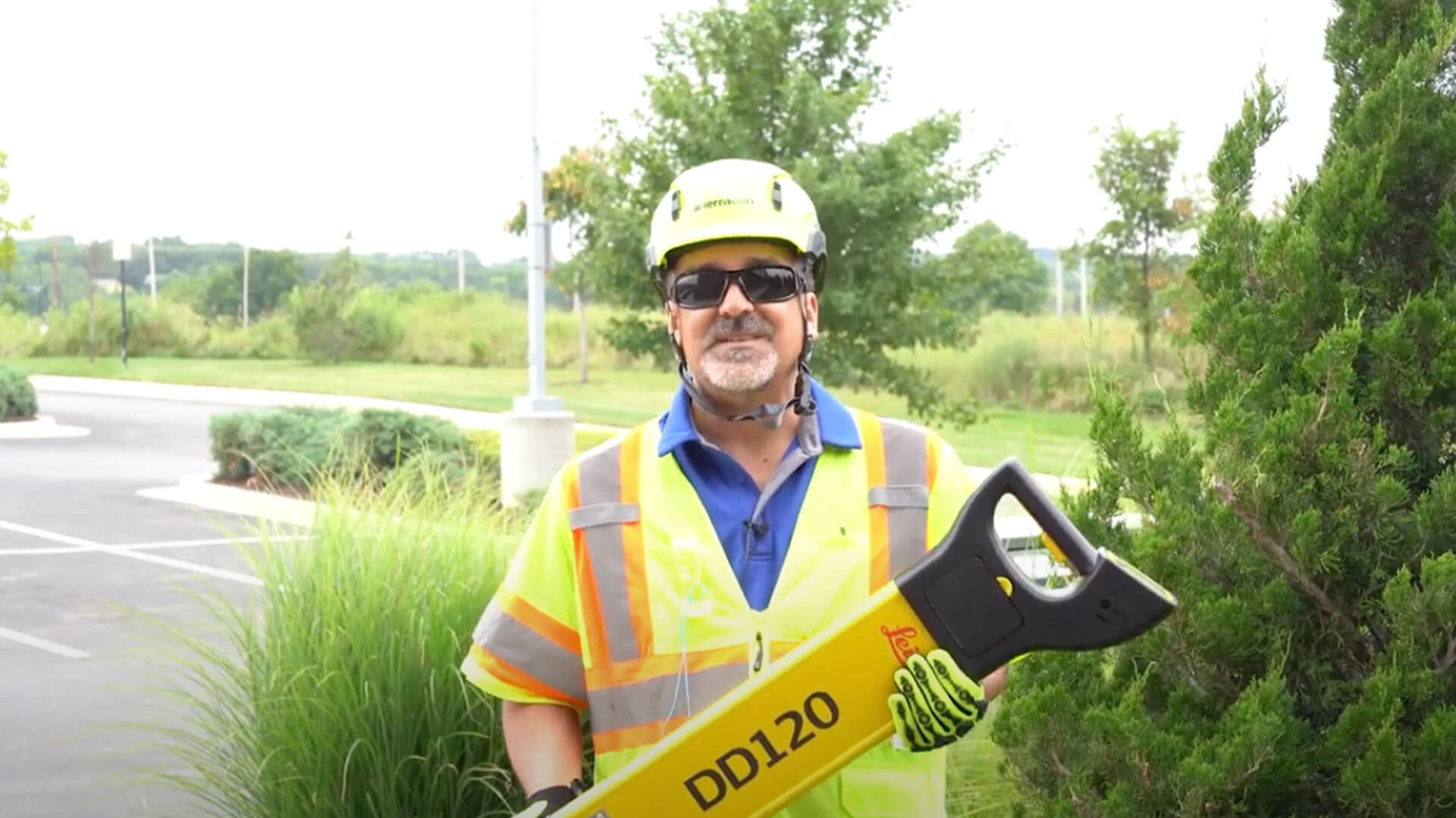 crew member holding a large piece of equipment while wearing safety gear